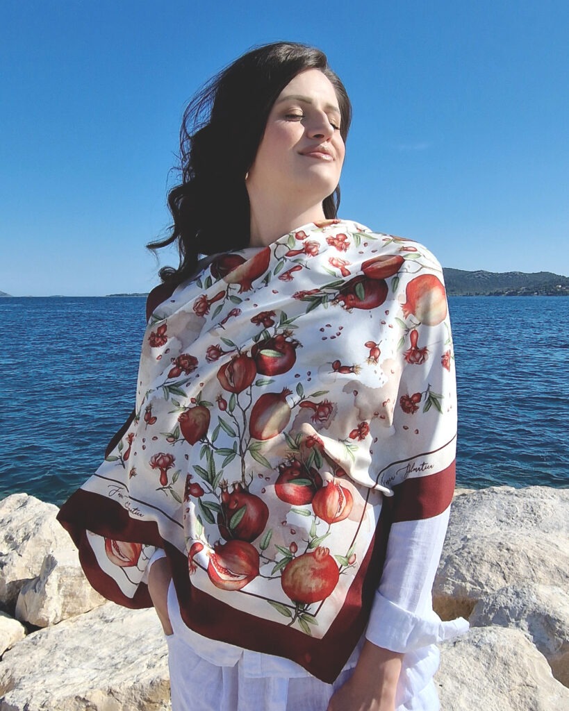 Fosca dalmatica Luksuzna svilena marama Fosca Dalmatica s autorskim ilustriranim motivom nara (šipka) na podlozi inspiriranoj Mediteranom.